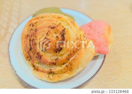 ガーリック味の渦巻きパンといちごメロンパン ガーリック味の渦巻きパンといちごメロンパン 115126468