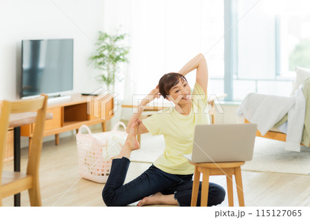 パソコンを見ながらストレッチをする女性 　 115127065