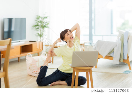 パソコンを見ながらストレッチをする女性 　 115127068