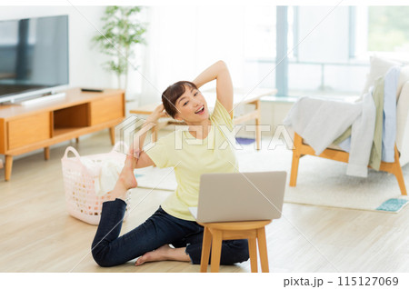 パソコンを見ながらストレッチをする女性 　 115127069