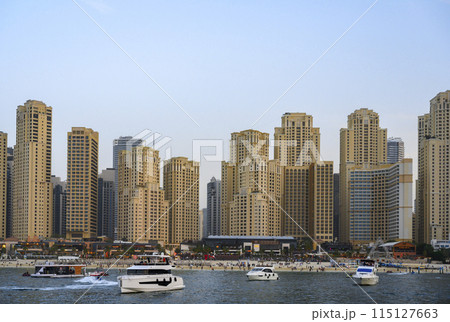 Sunset view of skyscrapers, beach and boats in Dubai, the Persian Gulf 115127663
