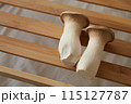木の板に乗せられた二つのエリンギ 115127787