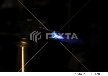 lit gas burner on a dark background lit gas burner on a dark background 115128330