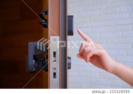 玄関扉を解錠する子供の手 115128550