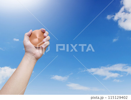 holding a bronze coin on the sky background Winner and success concept 115129402
