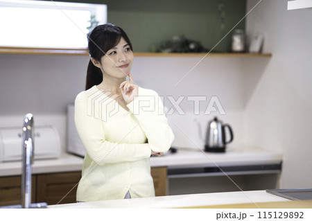 キッチンでくつろぐ笑顔の女性 115129892