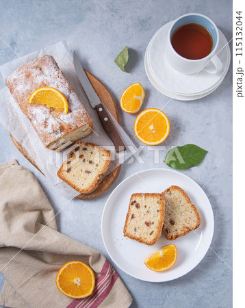 Concept breakfast. Freshly baked cake with raisins and orange on a cutting board Concept breakfast. Freshly baked cake with raisins and orange on a cutting board 115132044