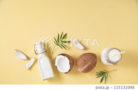 Healthy flat lay concept. Vegan milk bottles, coconut slices and palm branch Healthy flat lay concept. Vegan milk bottles, coconut slices and palm branch 115132098