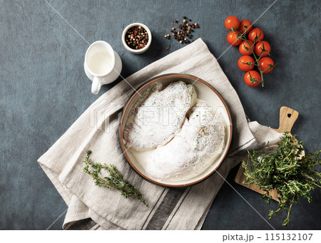 Chicken fillet in a creamy sauce with thyme in a bowl on a light background with fresh vegetables  115132107
