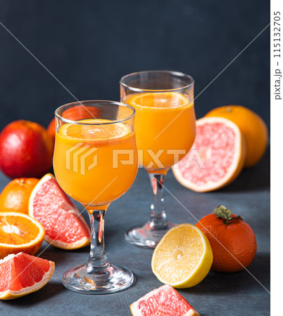 Citrus juice in two glasses and fresh fruit tangerine, orange, grapefruit and lemon  115132705