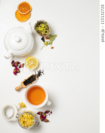 Flat lay a cup of black tea, fruit and herbal tea, with lemon and tea pot on a white background. Flat lay a cup of black tea, fruit and herbal tea, with lemon and tea pot on a white background. 115132728
