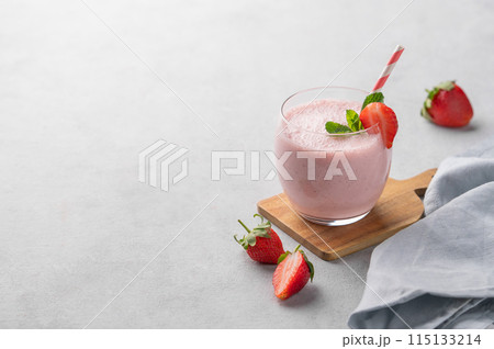 A glass of fresh strawberry smoothie with mint on a wooden board on a light background A glass of fresh strawberry smoothie with mint on a wooden board on a light background 115133214