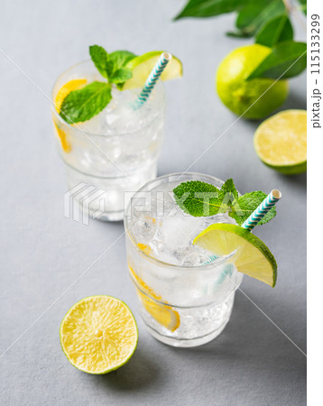 Two glasses of mojito cocktail or tonic with lemon, lime, mint and ice. Summer concept drink Two glasses of mojito cocktail or tonic with lemon, lime, mint and ice. Summer concept drink 115133299