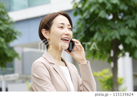 外でスマートフォンで電話をするビジネスウーマン 115135624