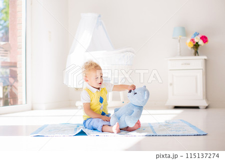 Little boy playing with toy teddy bear. Kids play. Little boy playing with toy teddy bear. Kids play. 115137274