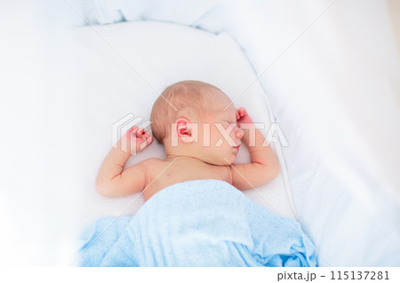 Little baby on white bed 115137281