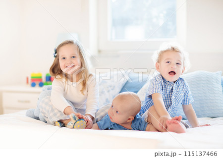 Kids in bed. Children in pajamas. Family bedroom. 115137466