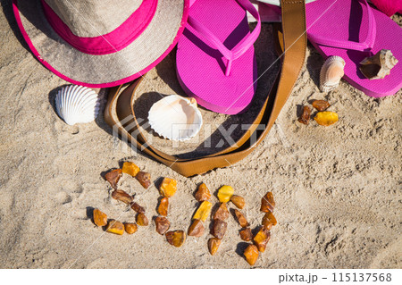 Inscription sun made of amber and different accessories for relax on sand Inscription sun made of amber and different accessories for relax on sand 115137568