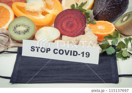 Inscription stop covid-19, fresh fruits with vegetables and protective mask Inscription stop covid-19, fresh fruits with vegetables and protective mask 115137697