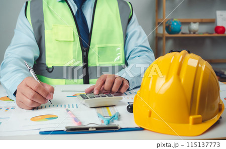 Architect or engineer sitting at desk in office, Cost calculation, Construction planning, structural calculation, Project construction cost planning and calculation, Project presentation plan. 115137773