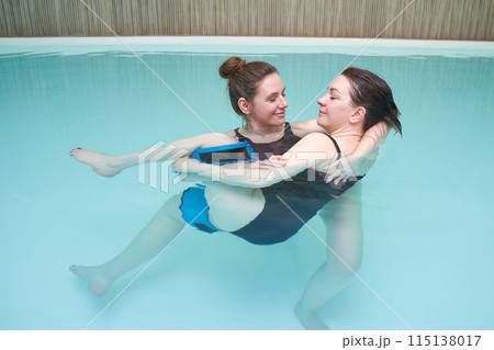 Two woman in pool. Watsu. Water rehabilitation massage. Aqua therapy exercise Two woman in pool. Watsu. Water rehabilitation massage. Aqua therapy exercise 115138017
