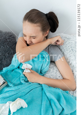 The teenager has a severe attack of acute coughing and coughing in the elbow with her eyes closed. The teenager has a severe attack of acute coughing and coughing in the elbow with her eyes closed. 115139172