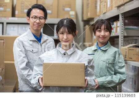 段ボールを持つ作業着姿の女性と男女の作業員 段ボールを持つ作業着姿の女性と男女の作業員 115139603