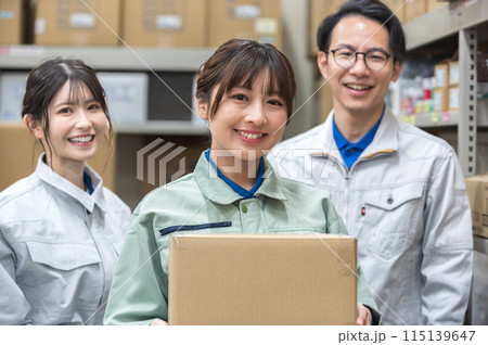 段ボールを持つ作業着姿の女性と男女の作業員 段ボールを持つ作業着姿の女性と男女の作業員 115139647