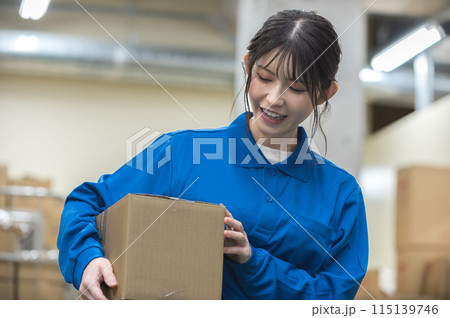 倉庫で段ボールを持つ若い女性 倉庫で段ボールを持つ若い女性 115139746