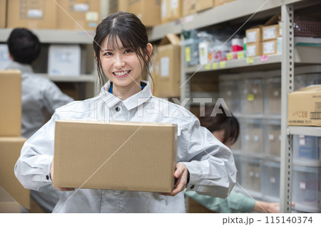 段ボールを持つ作業着姿の女性 段ボールを持つ作業着姿の女性 115140374