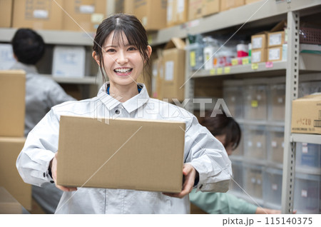 段ボールを持つ作業着姿の女性 115140375