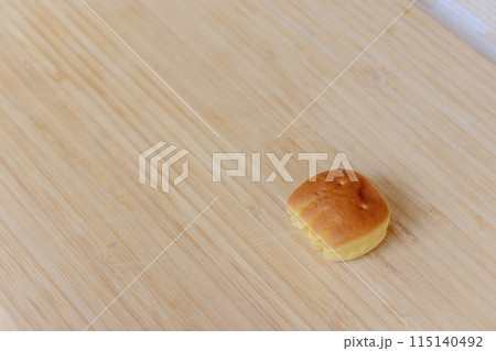 木のテーブルの上にある赤ちゃんの手の様なパン 115140492