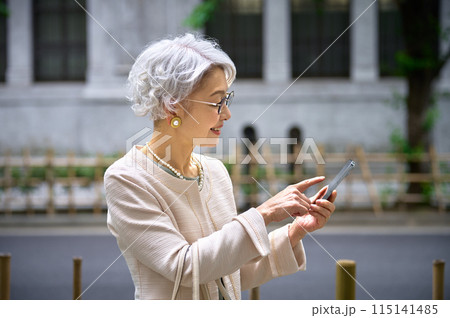 スマホを操作する上品なシニア女性 スマホを操作する上品なシニア女性 115141485