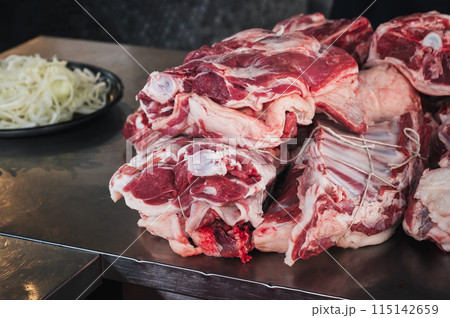 Fresh raw lamb meat on counter for cooking traditional Asian Uzbek pilaf in restaurant Besh Qozon in Tashkent in Uzbekistan Fresh raw lamb meat on counter for cooking traditional Asian Uzbek pilaf in restaurant Besh Qozon in Tashkent in Uzbekistan 115142659