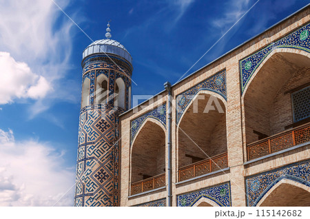 Brick walls decorated with ceramic tiles with oriental pattern of Kukeldash madrasah in Uzbekistan in Tashkent. Ancient old Islamic madrassa on background of blue sky 115142682