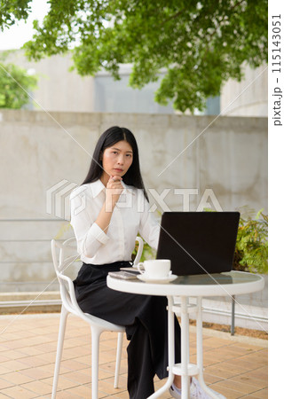 Young woman working on laptop at outdoor terrace cafe with coffee, business concept 115143051