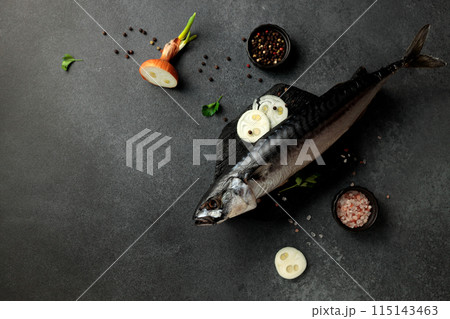 Dried mackerel herring on a black cutting board on a black background 115143463