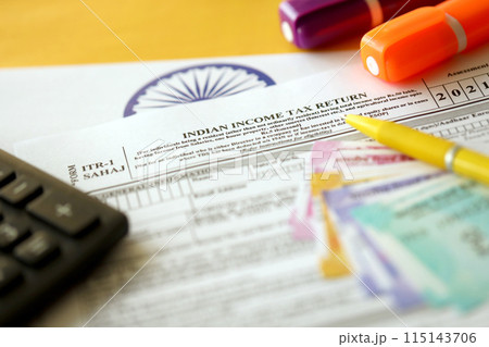 Indian income tax return blank form with pen and indian rupees bills on indian country flag close up. Annual tax report concept 115143706