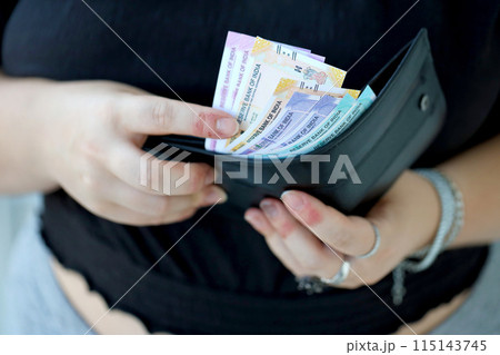 Woman hand with indian rupees bills close up. Concept of financial operations in cash in India 115143745