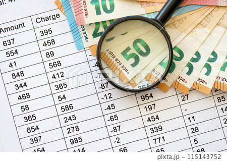 Business and savings concept with many euro money bills and magnifying glass close up 115143752