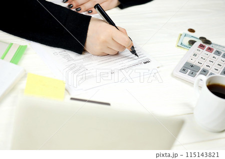 Accountant fill American tax form 1040 Individual income tax return in end of tax period. Taxation and paperwork routine in United States Accountant fill American tax form 1040 Individual income tax return in end of tax period. Taxation and paperwork routine in United States 115143821