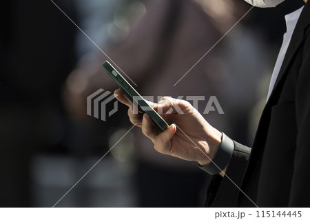 スマートフォンを持つビジネスマンの手元 スマートフォンを持つビジネスマンの手元 115144445
