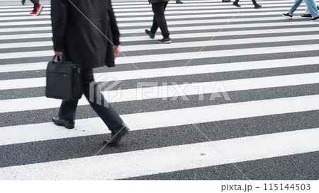 昼の都心の交差点の横断歩道を渡る出勤する人々の様子 115144503