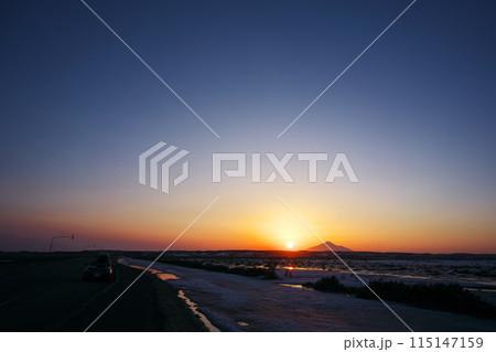早春の北海道道444号線から利尻山の南に沈む太陽を臨む 115147159