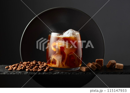 Iced coffee with cream on a black background. Iced coffee with cream on a black background. 115147933