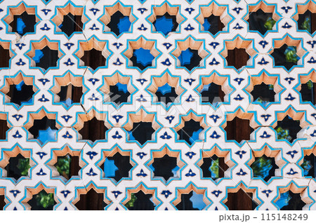 ancient lattice of ceramic tiles with star pattern on window of the old Islamic mosque Hazrati Imam in Uzbekistan 115148249