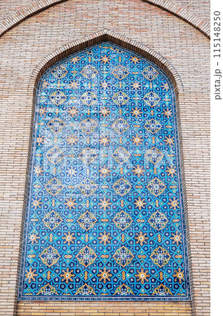 ancient ceramic tile with traditional Uzbek ornament Arabic Islamic pattern on wall of the medieval Muslim mosque Hazrati Imam in Uzbekistan 115148250