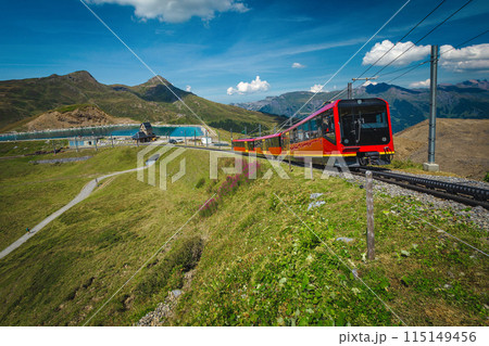Red tourist train and mountain lake in background, Grindelwald, Switzerland 115149456