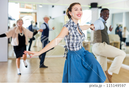 Cheerful female practicing lindy hop in pair with man 115149597
