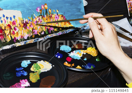 Person painting with blue brush on table with nails and accessories 115149845